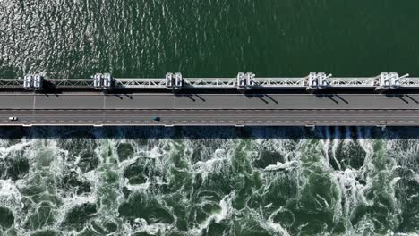 aerial top down shot of car driving on zeeland bridge at delta works construction projects in netherlands during sunny day - storm surge barrier against flood
