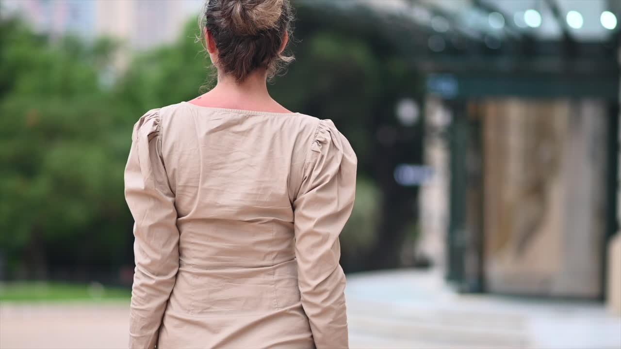 Woman in brown dress posing in Monte Carlo district, Monaco cityscape