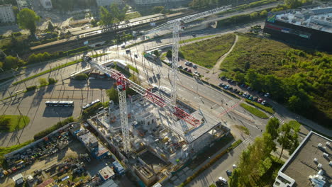 erected tower cranes at the construction site in gdynia, poland - ascending drone shot