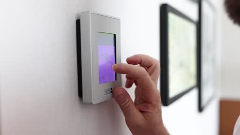 person adjusting a smart thermostat for climate control