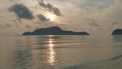 Ruhiger-Morgen-Mit-Blick-Auf-Eine-Thailändische-Insel,-Mit-Sanftem-Sonnenlicht,-Das-Sich-Auf-Dem-Meerwasser-Spiegelt