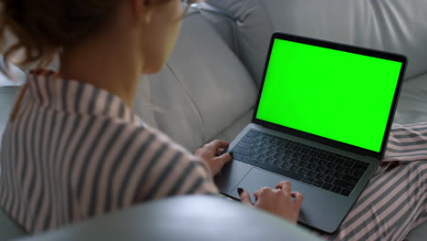 Woman-looking-green-screen-laptop-at-remote-workplace-closeup.-Girl-browsing-web