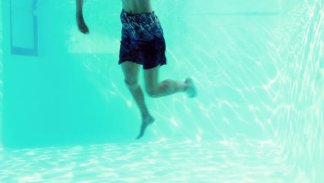 happy couple jumping in swimming pool together
