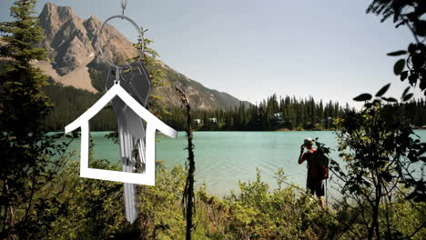 animation of silver house and key over caucasian man at lake