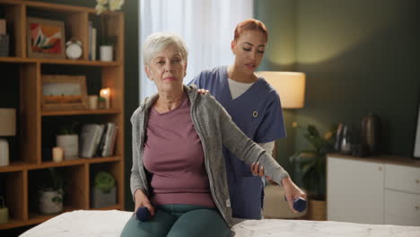senior woman doing physical therapy with caregiver