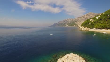 people kayaking in sea, green nature and mountain