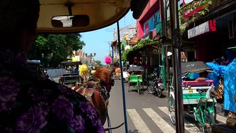 yogyakarta, a cultural place to go in indonesia; a gig, like the kalesa or karatela, is a city tour ride to experience, horse and carriage ride contrasting modern vehicle on paved roads.
