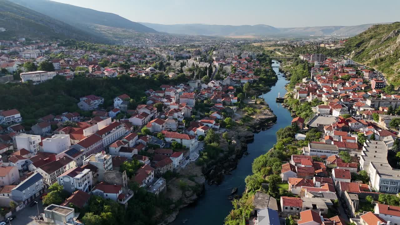 Letecký pohled dronem na město Mostar v Bosně a Hercegovině, balkánské zemi, se starým mostem Stari Most přes řeku Neretvu, v létě, v červenci.