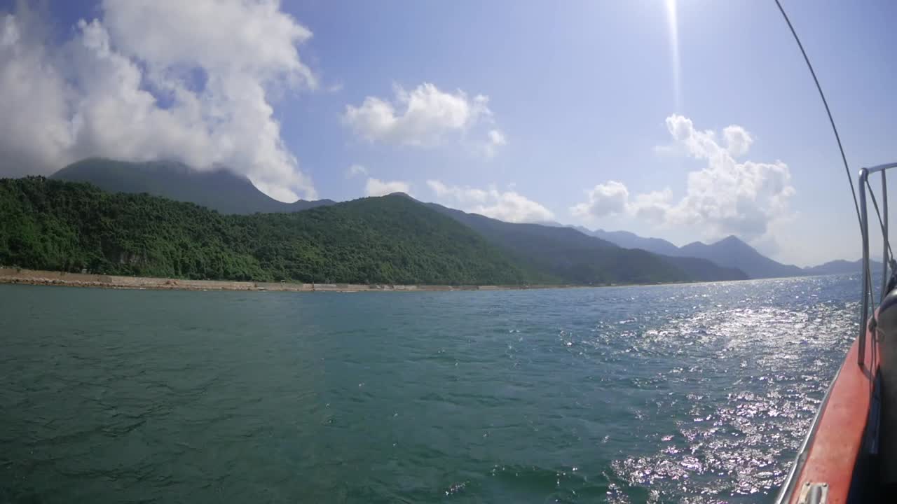 Cruising on a bumpy boat in a sea along the coast of breathtaking mountains