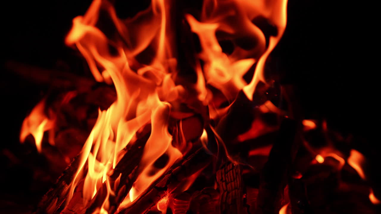 Bastoncini di legno che bruciano nel falò. Piacevole, confortante e rilassante vista di un fuoco di notte. Primo piano
