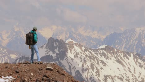 Mujer-Excursionista-De-Pie-Logrando-La-Cima.-Vista-A-Las-Montañas-Nevadas.