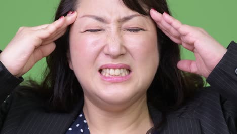mature beautiful asian businesswoman having headache