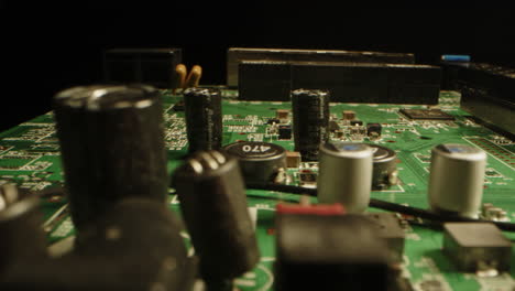 cinematic dolly of a printed circuit board with components in a dark studio