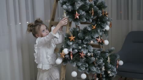 little girl decorating a christmas tree