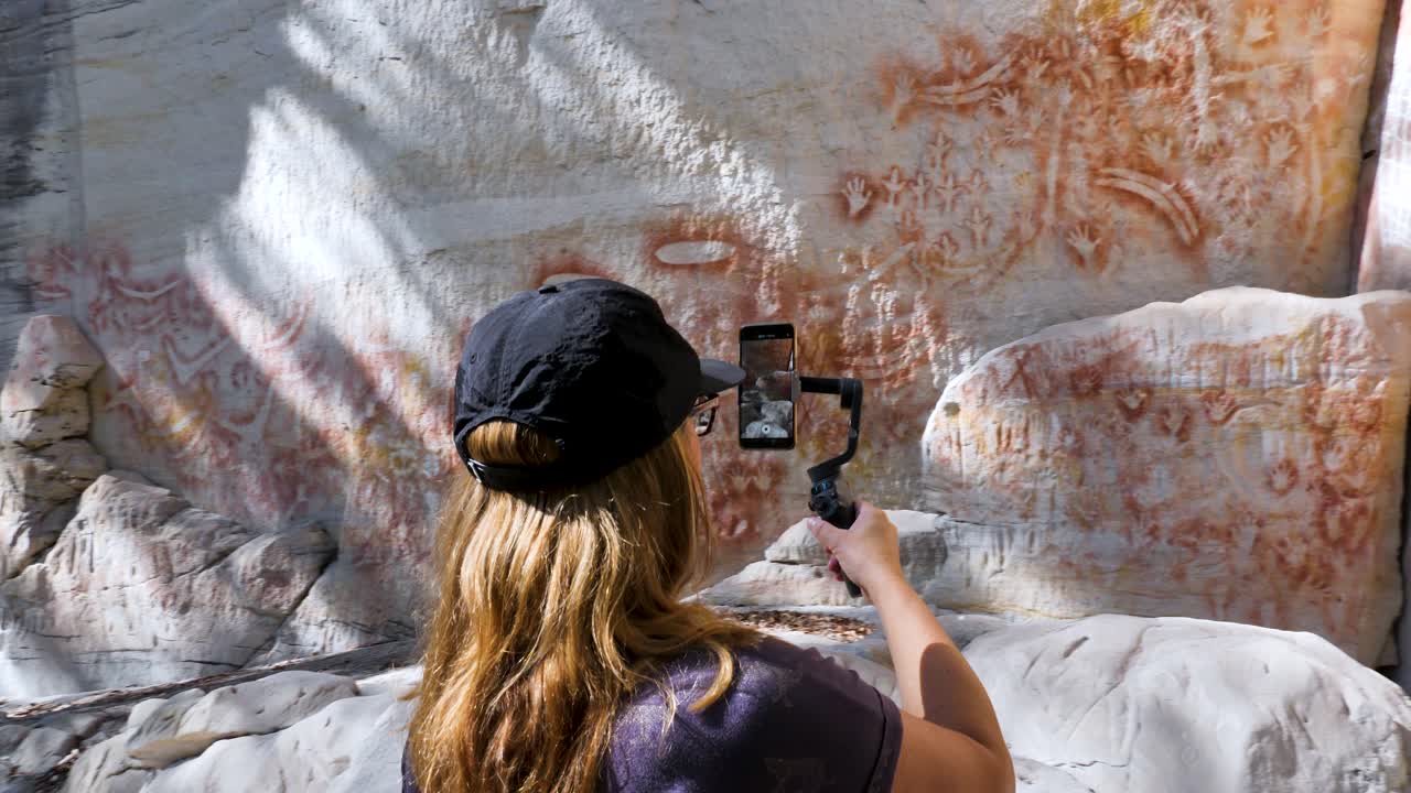 Donne che riprendono un video di pitture rupestri aborigene a Carnarvon Gorge, Queensland, Australia
