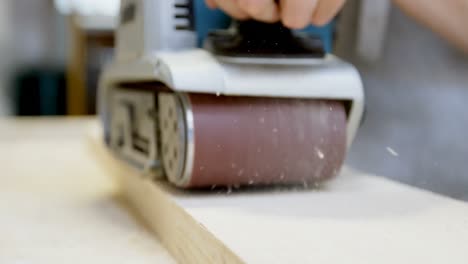 female welder using wood sanding machine 4k