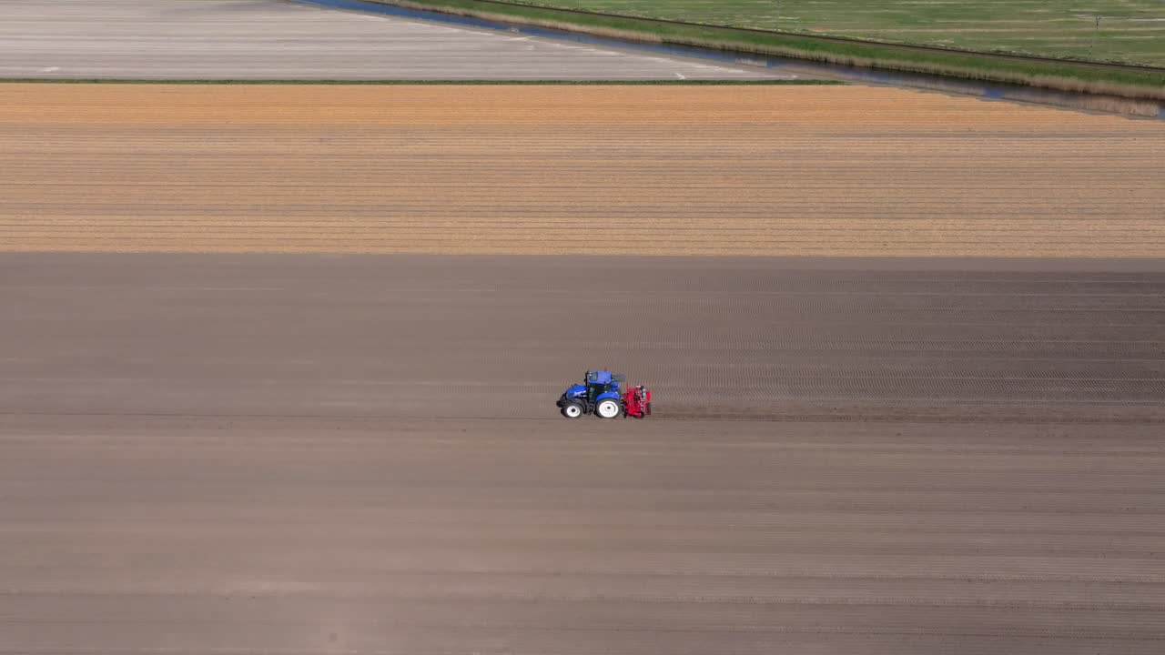 Vista aerea di un trattore agricolo che semina in una prateria rurale, Olanda