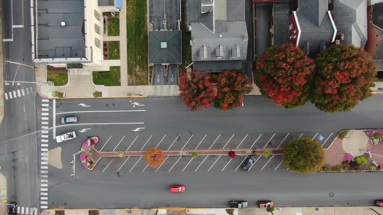 미국 국기가 펄럭이는 마을 광장의 영화 같은 하향식 공중 오버헤드