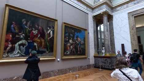 people observing paintings in a museum gallery