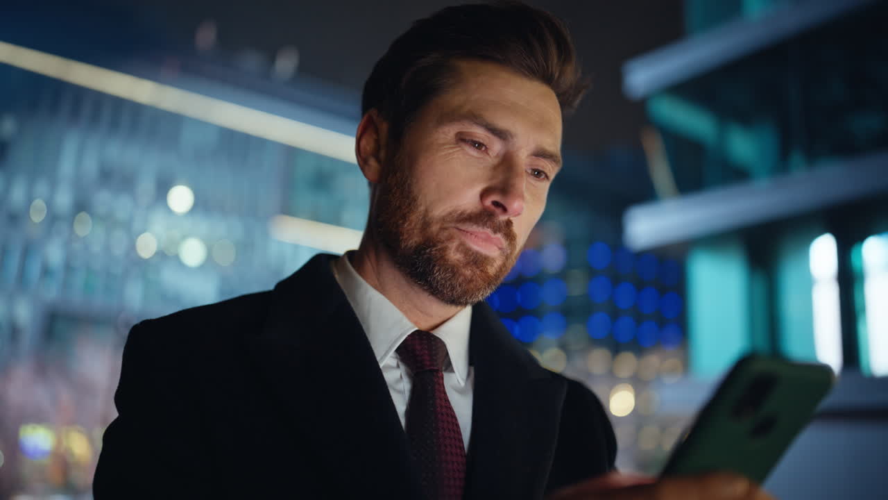 Closeup guy hands typing on mobile phone on night city street. Thoughtful ceo