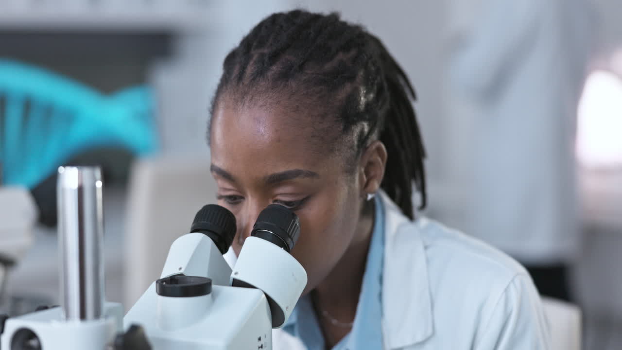 Black woman, scientist and microscope