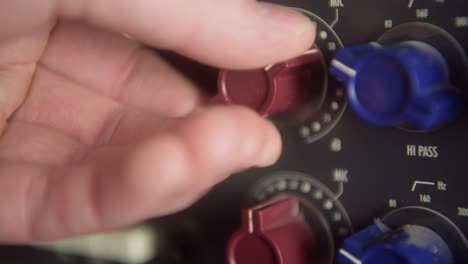 adjusting the input and high pass dial of a vintage analog recording studio microphone preamp