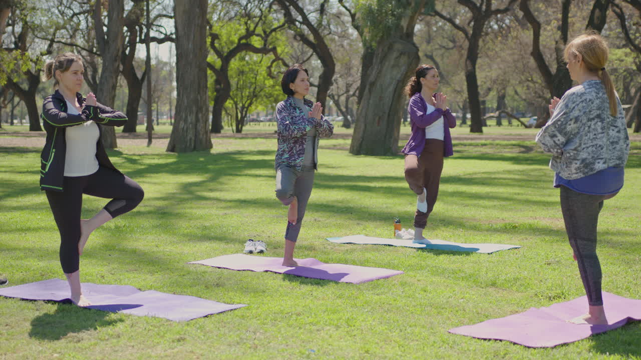 mujeres practicando yoga en un parque