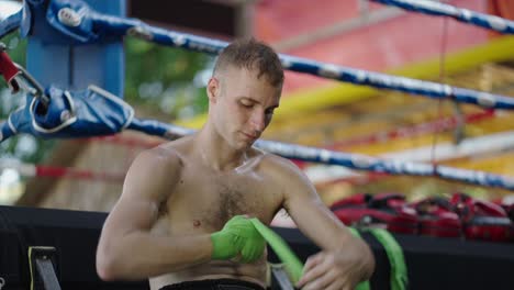man wrapping hands in a boxing ring