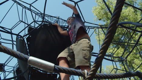 a boy moves carefully in a children's rope climb