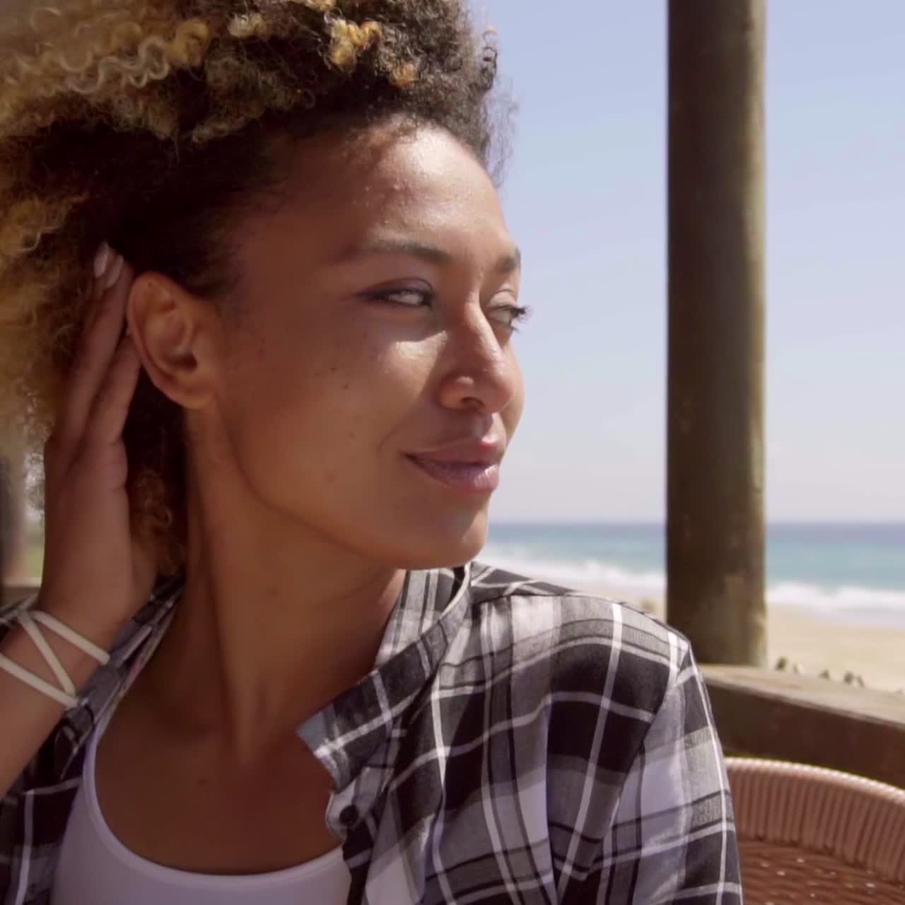 Adorable afro girl sitting in beach bar