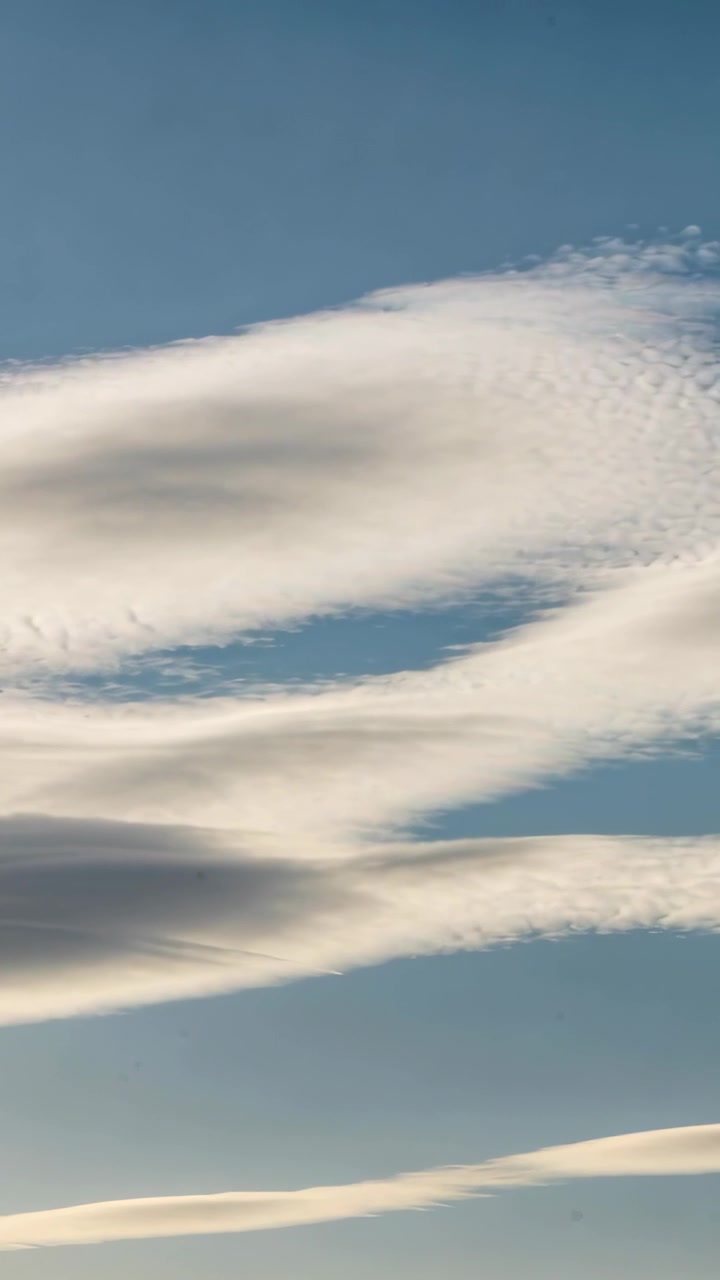Video verticale: Inquadrature iniziali che mostrano lunghi strati di nuvole che fluttuano nel cielo blu, il vento che forma le nuvole.