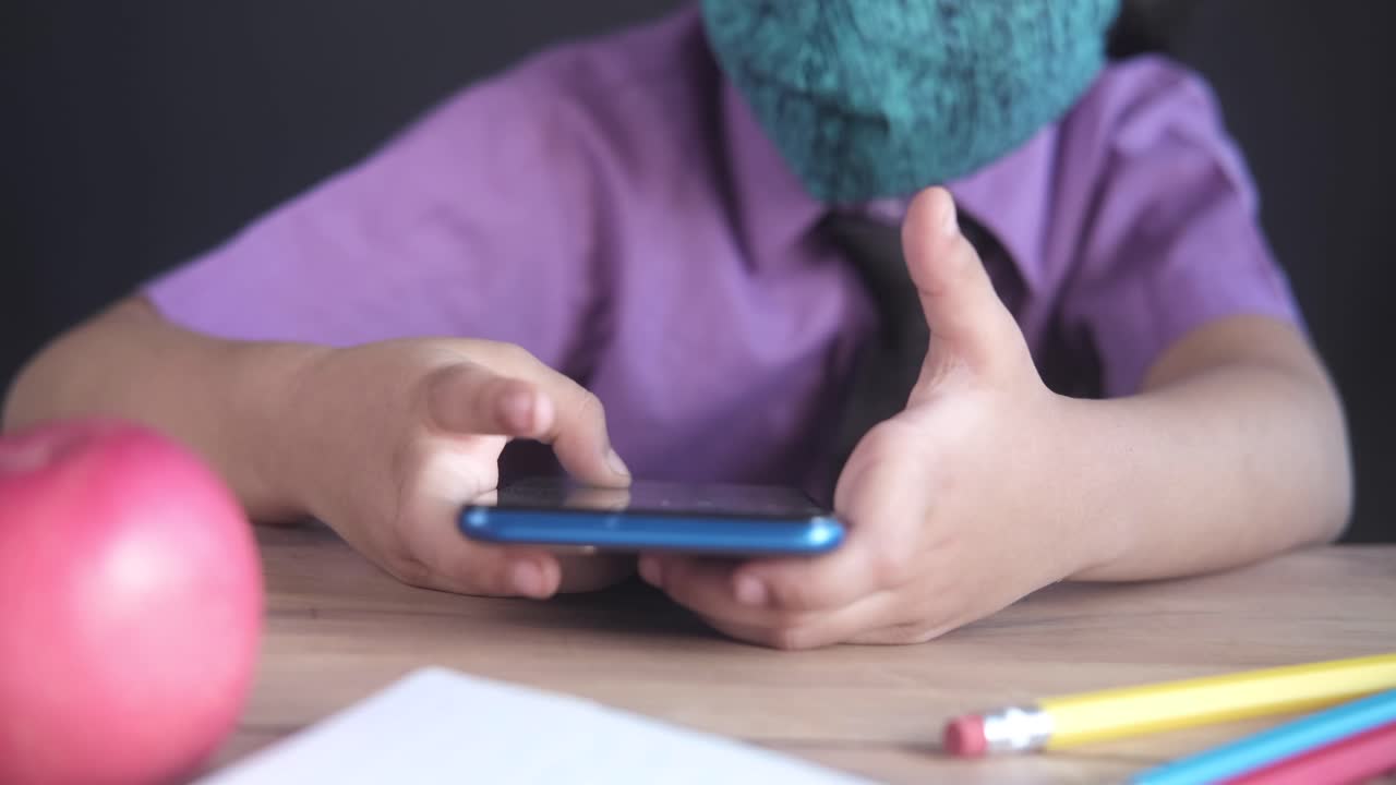 niño que utiliza un teléfono inteligente durante el aprendizaje a distancia