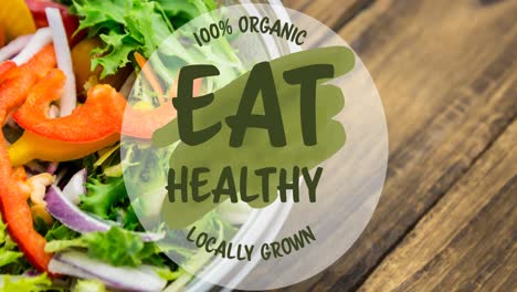 animation of eat healthy locally grown text in green, over bowl of fresh salad on wooden boards