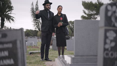 couple, sad and mourning at tombstone