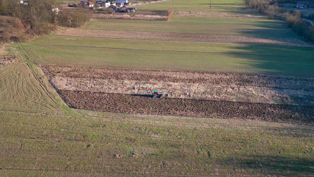 Aerial Drone Shot of Tractor Plowing Agricultural Field at Sunset in Rural Countryside food supply