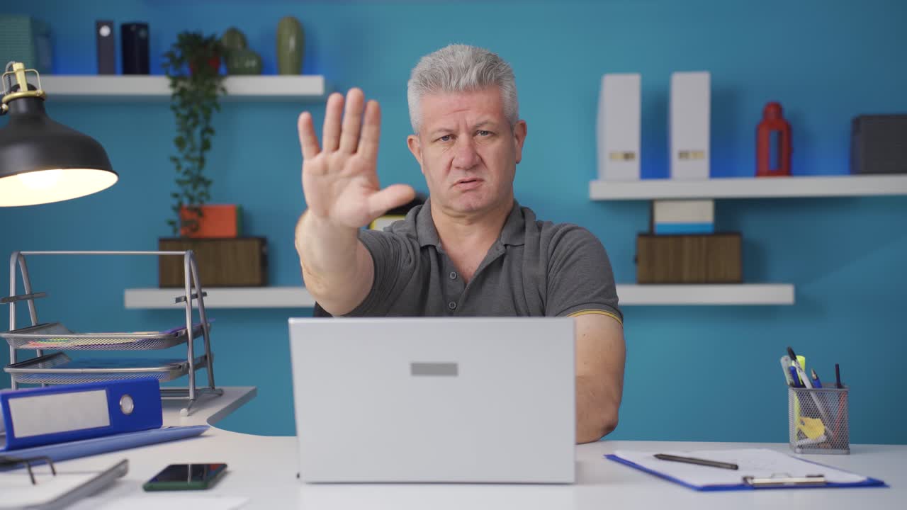 Home office worker man says stop to camera, warns.