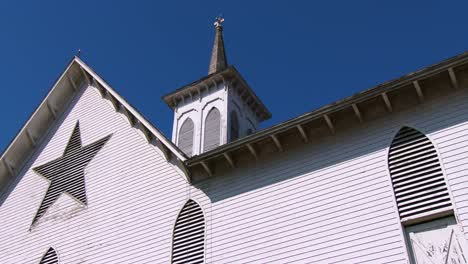 a white amish style barn in rural pennsylvania has a pentagram like star painted on it