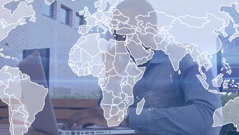 animation of world map over african american businessman using laptop and talking on smartphone