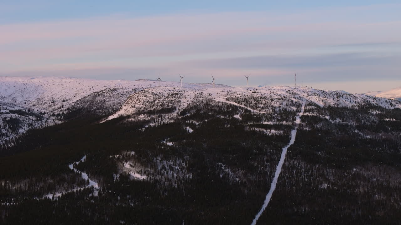 Aerial view of wind turbines atop snow-covered mountains near Fish Lake in Whitehorse, Yukon. A stunning blend of renewable energy and pristine Canadian wilderness
