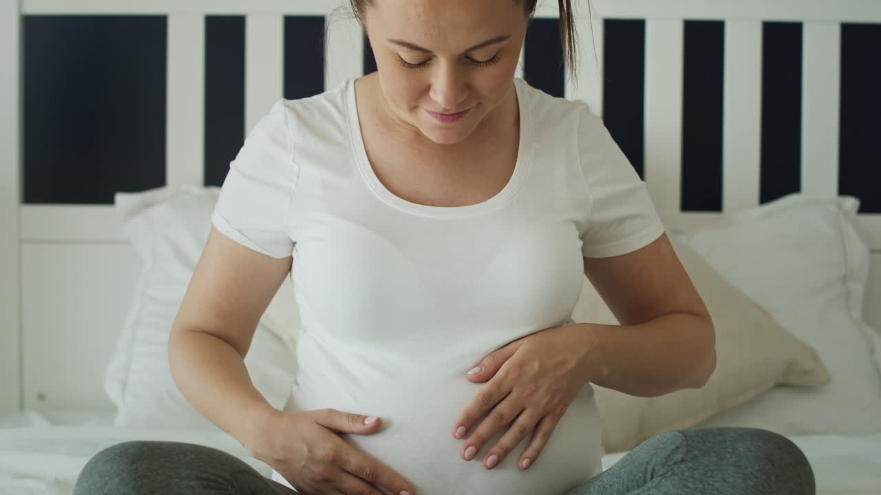 vídeo de retrato de una mujer embarazada en la cama.