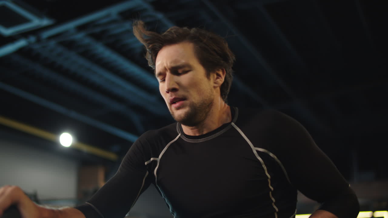 피트니스 센터에서 운동 자전거를 사용하는 피곤한 피트 남자. 체육관에서 따뜻해지는 스포츠 남자