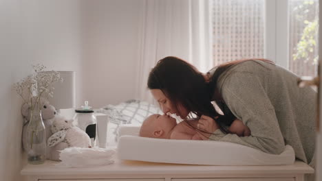 행복한 엄마가 부드럽게 키스하는 아기 즐기는 사랑하는 엄마가 집에서 변기 테이블에서 유아를 놀이로 돌보는 그녀의 신생아와 연결을 공유하는 건강한 보육