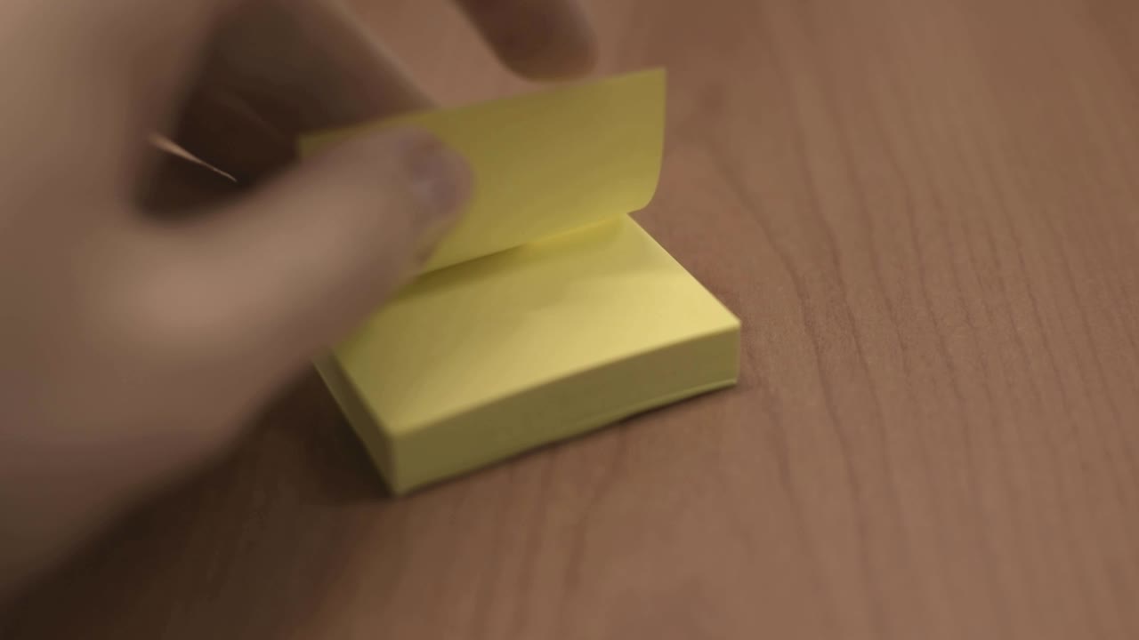 Rapidly turning yellow sticky note pages, taking only one