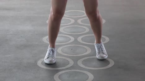 person playing hopscotch on a patterned floor