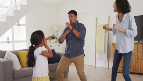 Glückliche-Hispanische-Familie-Mit-Tochter,-Die-Tanzt-Und-Spaß-Im-Wohnzimmer-Hat