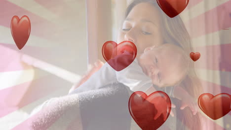 animación de corazones cayendo sobre mujer caucásica sosteniendo un bebé