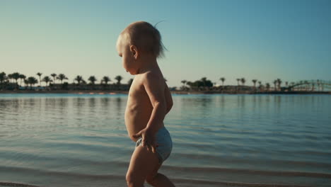 Entzückendes-Süßes-Kind,-Das-Entlang-Der-Küste-Spaziert.-Glücklicher-Junge,-Der-Am-Strand-Wasser-Spritzt.