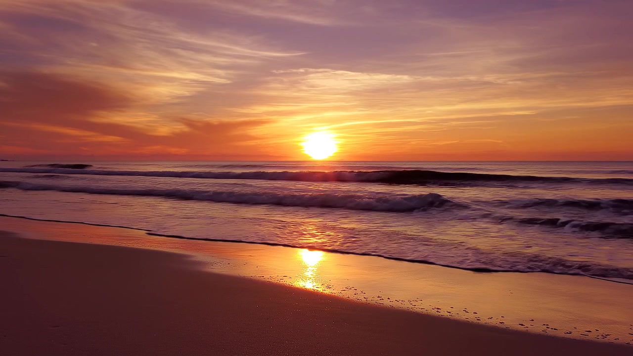 Vibrant sunrise reflecting on wet beach sand at dawn