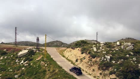 off-road vehicle driving at the road amidst the rugged landscape on a cloudy sky in lebanon