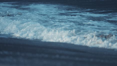 las poderosas olas ruedan en las aguas poco profundas de arena en la playa de ersfjord